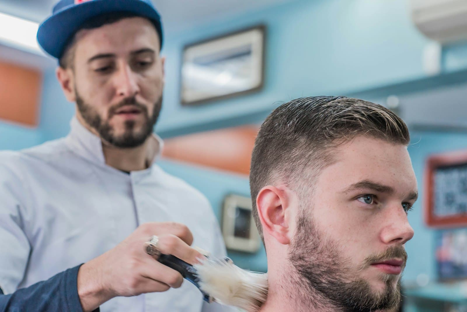 Barbero cortando el cabello a un cliente en su sillón