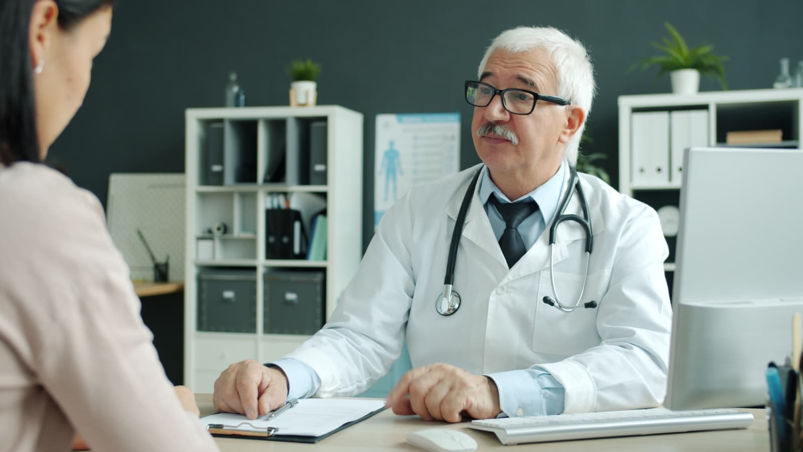 Médico especialista conversando con una paciente en consulta