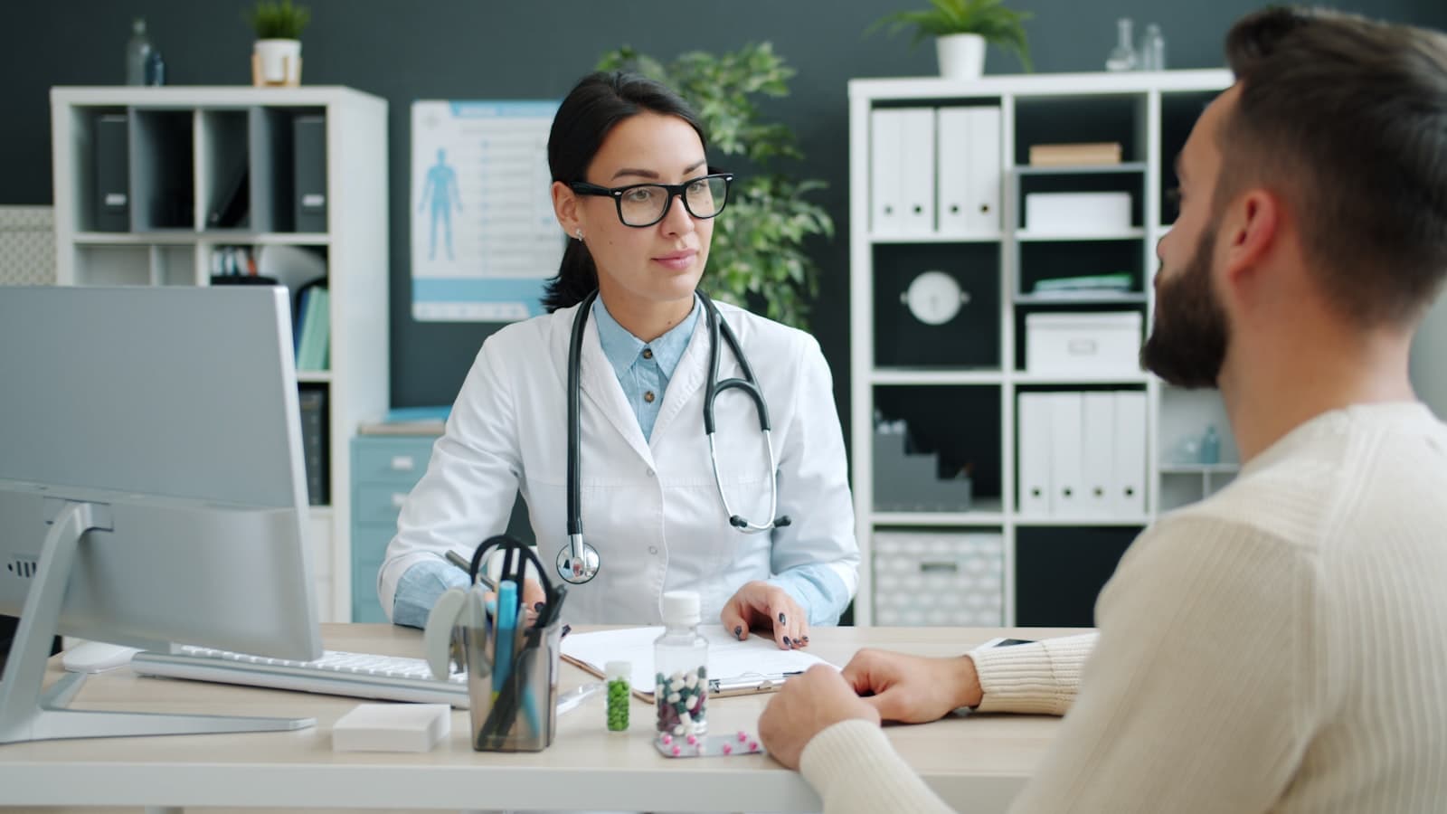 Doctora consultando con un paciente en un consultorio moderno